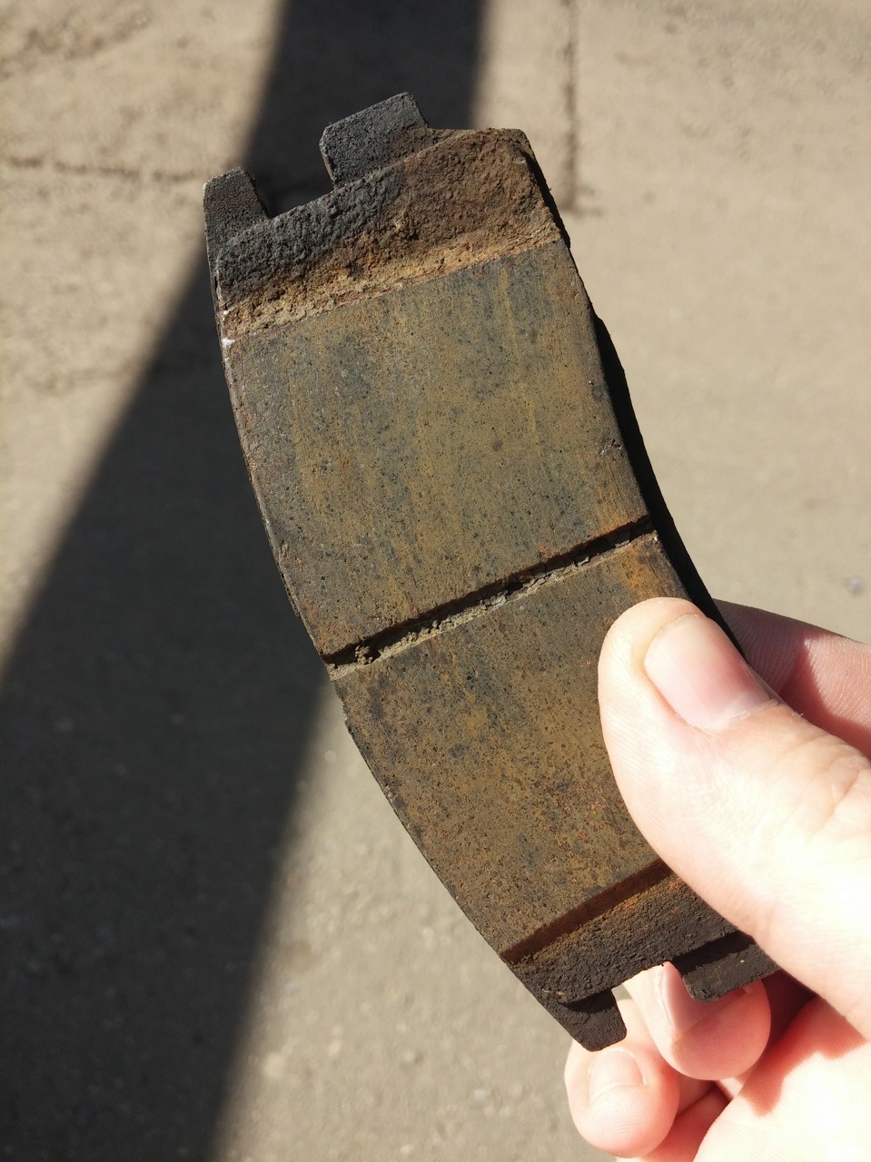 старая тормозная колодка в руке