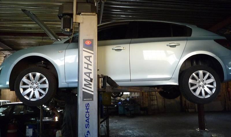 серый Шевроле Круз на подъемнике сбоку